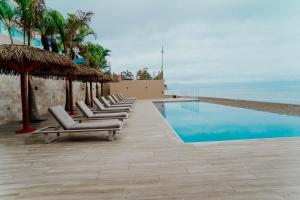 a row of lounge chairs next to a swimming pool at MantaHost Hotel in Manta