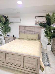 a large bed in a bedroom with two plants at Vessel Hotel Studio Suites of Atlanta, GA in Atlanta