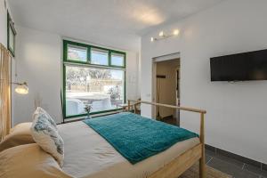 a bedroom with a bed and a flat screen tv at Esquina Canaria in El Carretón