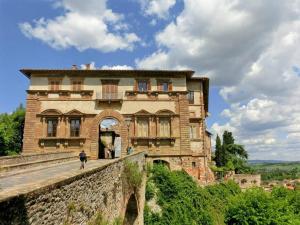 a man walking in front of a large building at Bright central apartment in Colle di Val d'Elsa