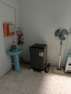 a small room with a sink and a fan at homestay melang in Kuala Pilah