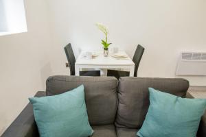a living room with a couch with pillows and a table at Cosy 1 Bedroom Apartment in Central Blackburn in Blackburn +7 photos