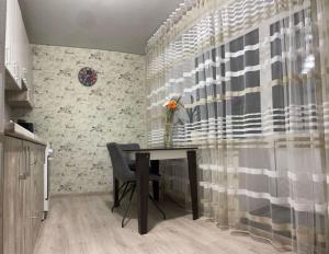 a dining room table with a vase of flowers on it at чудова охайна квартира in Sumy