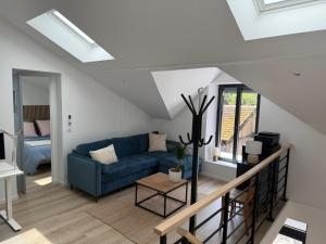 a living room with a blue couch and a table at Dépendance près de Fontainebleau in Vulaines-sur-Seine