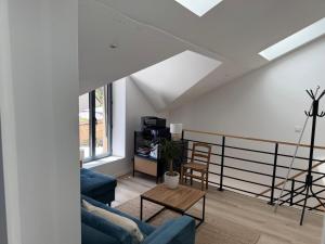 a living room with two blue couches and a table at Dépendance près de Fontainebleau in Vulaines-sur-Seine