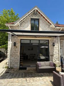 a glass extension of a house with a couch at Dépendance près de Fontainebleau in Vulaines-sur-Seine