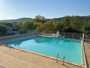 a large blue swimming pool with a fence around it at Mazet du soleil in Saint-Martin-de-Brômes +43 photos