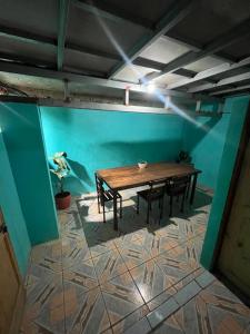 a table and chairs in a room with a blue wall at Hostel Mar y Bosque in Drake +12 photos