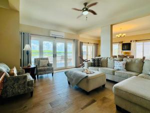 a living room with a couch and chairs and a fan at Lina Point Belize Overwater Resort in San Pedro