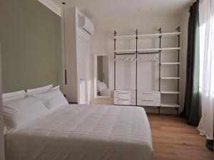 a white bedroom with a bed and a closet at Il Giardino Segreto in Alba