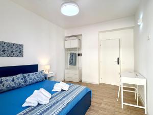 a bedroom with a blue bed and a desk at B&B Salty Mermaid in Tropea