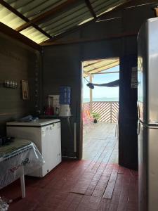 a kitchen with an open door to a deck at Brisa do Mar in Macajatuba