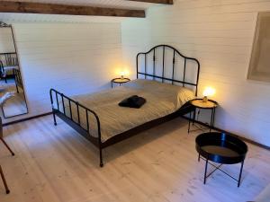 a bed in a room with two tables and two lamps at Baltic Beach Cozy Tiny House B in Pērkone +14 photos