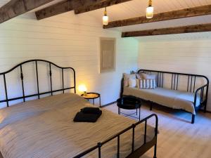 a bedroom with two beds and a couch at Baltic Beach Cozy Tiny House B in Pērkone