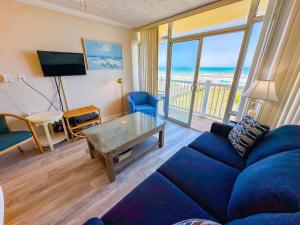a living room with a blue couch and a view of the ocean at Grand Strand Resort II 18 in North Myrtle Beach