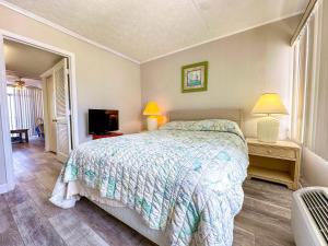 a bedroom with a bed and a flat screen tv at Grand Strand Resort II 18 in North Myrtle Beach +8 photos