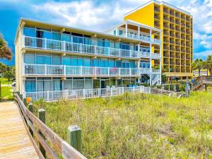 a large building on the beach with a wooden boardwalk at Grand Strand Resort II 18 in North Myrtle Beach