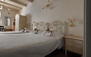 a bedroom with two large beds with white sheets at Nei pressi dei Sassi in Matera