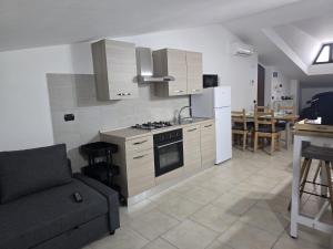 a kitchen with a couch and a stove top oven at Caly Home in Caserta