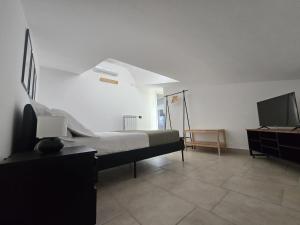 a bedroom with a bed and a flat screen tv at Caly Home in Caserta