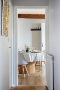 a dining room with a table with a white table cloth at Chez Ismarita & Jérôme - Tout Dax à pied - Wifi in Dax