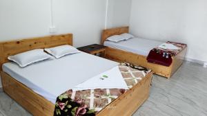 two twin beds in a room withthritisthritisthritisthritisthritisthritisthritisthritisthritis at Pratima's Cloud House in Kalimpong