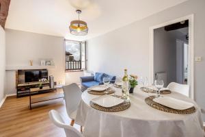 a dining room with a white table and chairs at Chez Ismarita & Jérôme - Tout Dax à pied - Wifi in Dax