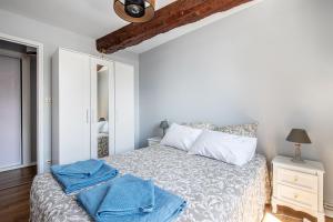 a bedroom with a bed with blue towels on it at Chez Ismarita & Jérôme - Tout Dax à pied - Wifi in Dax +11 photos