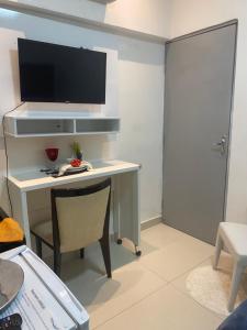 a room with a desk with a television on a wall at Alugo suites mobiliado centro com áreas sociais Picina in Araguaína