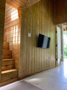 a room with a television on a wooden wall at Indómito Chalet-El Yunque Zone in Juncos
