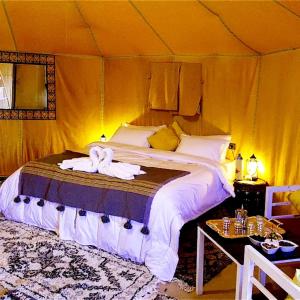 een slaapkamer met een bed in een tent bij Horaz Merzouga Camp in Merzouga