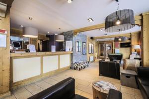 a restaurant with a bar with leather chairs and tables at Résidence Les Crêts - maeva Home - 3 Pièces 6 Personnes - Confort MAE-1026 in Les Allues