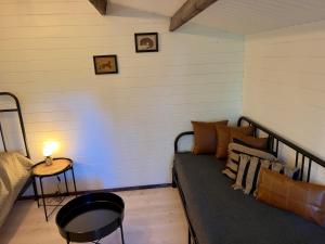 a room with a bed and a table with a lamp at Baltic Beach Charm Tiny House C in Pērkone +9 photos
