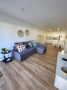 ein Wohnzimmer mit einer blauen Couch und einer Küche in der Unterkunft Villa Rica in Azeitão
