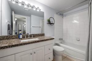 a bathroom with a sink and a tub and a toilet at Cozy & Spacious 2BR in Downtown very close to Stampede and 17th Ave with Parking and AC in Calgary +26 photos