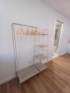 ein Schrank mit einem Metallgestell mit Kleiderbügeln und Schuhen in der Unterkunft Villa Rica in Azeitão