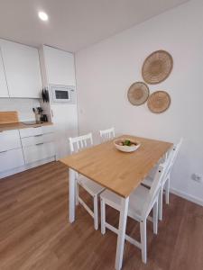 eine Küche mit einem Holztisch und weißen Schränken in der Unterkunft Villa Rica in Azeitão