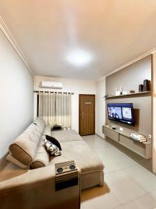 a bedroom with a large bed and a flat screen tv at Casa Aconchegante Saboto in Foz do Iguaçu