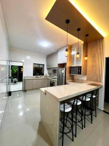 a kitchen with a large island with bar stools at Casa Aconchegante Saboto in Foz do Iguaçu