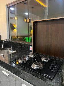 a stove top in a kitchen with a sink at Casa Aconchegante Saboto in Foz do Iguaçu