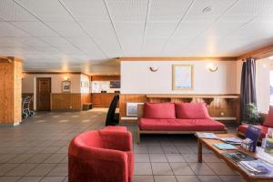 a living room with a red couch and two chairs at Résidence Les Valmonts - maeva Home - Appartement 3 pièces 6 personnes Sélection MAE-7194 in Saint-Martin-de-Belleville