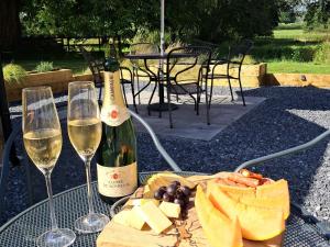 a table with two glasses of wine and cheese at Carreg Cennen Cottage in Carmarthen +25 photos