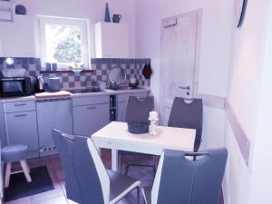 a small kitchen with a table and chairs in it at Ferienhausidylle mit Motorboot am See in Basedow
