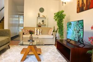 a living room with a couch and a tv at Charming 3-Bedroom Townhouse with Garden & Balcony - Lavington, Nairobi in Nairobi