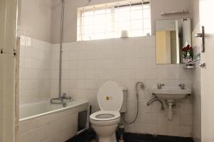 a bathroom with a toilet and a sink at Charming 3-Bedroom Townhouse with Garden & Balcony - Lavington, Nairobi in Nairobi +21 photos