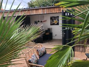 un patio con sedia e palme di Bluebell cottage a Saleignes