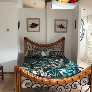una camera con letto in legno e copriletto floreale. di Bluebell cottage a Saleignes