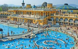 a large pool in a building with people in it at Eden Apartment Budapest in Budapest