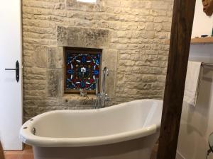 un bagno con vasca e finestra istoriata di Bluebell cottage a Saleignes Altre 35 foto