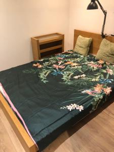 un letto con una coperta verde con dei fiori sopra di Bluebell cottage a Saleignes